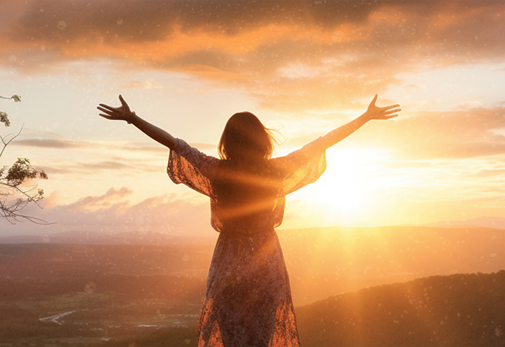 woman holding hands up reflecting wholeness